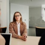 Young woman attending a job interview in a modern office, showcasing confidence and professionalism.